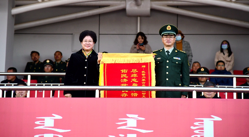 黄雅丽代表学校向武警内蒙古总队机动支队支队长王存宝赠送了锦旗.